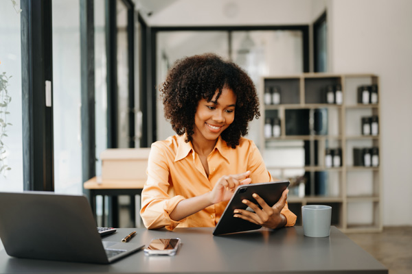 Business woman using tablet and laptop for doing math finance on