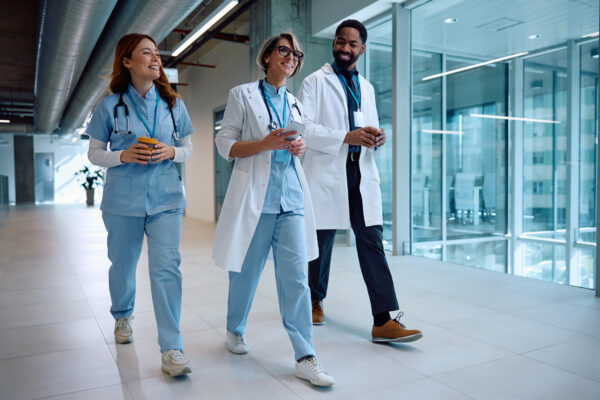 Multiracial group of medical employees walking together at a medical facility.